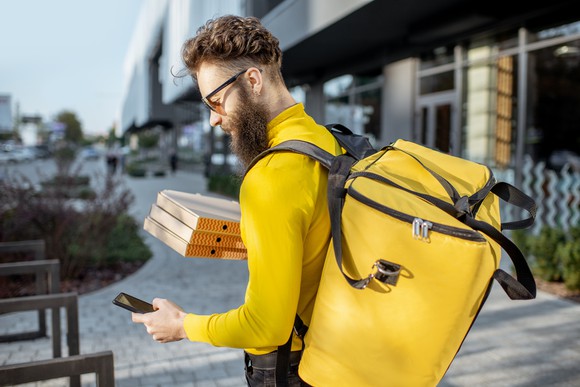 A deliveryman checks his smartphone.