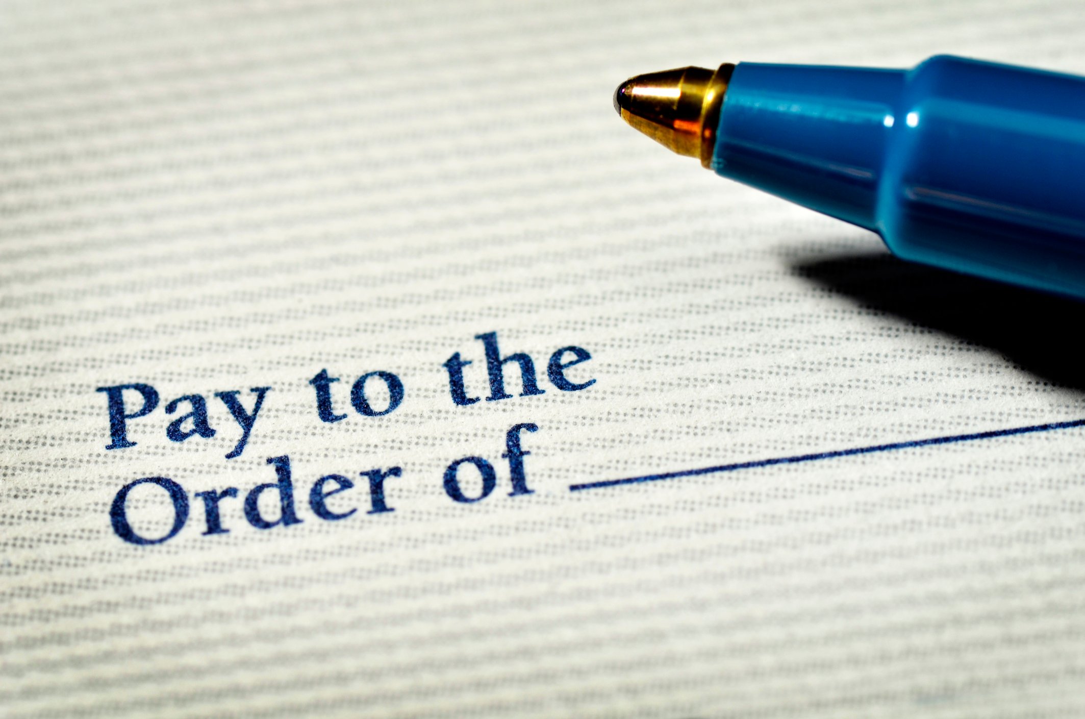 A pen nib and the payment line of a blank check. 