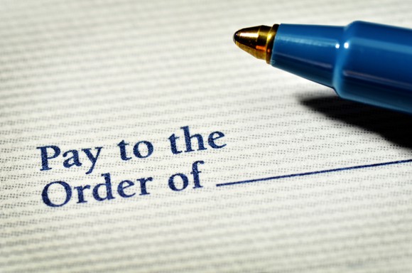 A pen nib and the payment line of a blank check. 