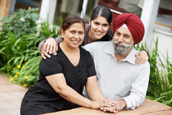 A sikh family is shown -- middle-aged parents and a young adult daughter.