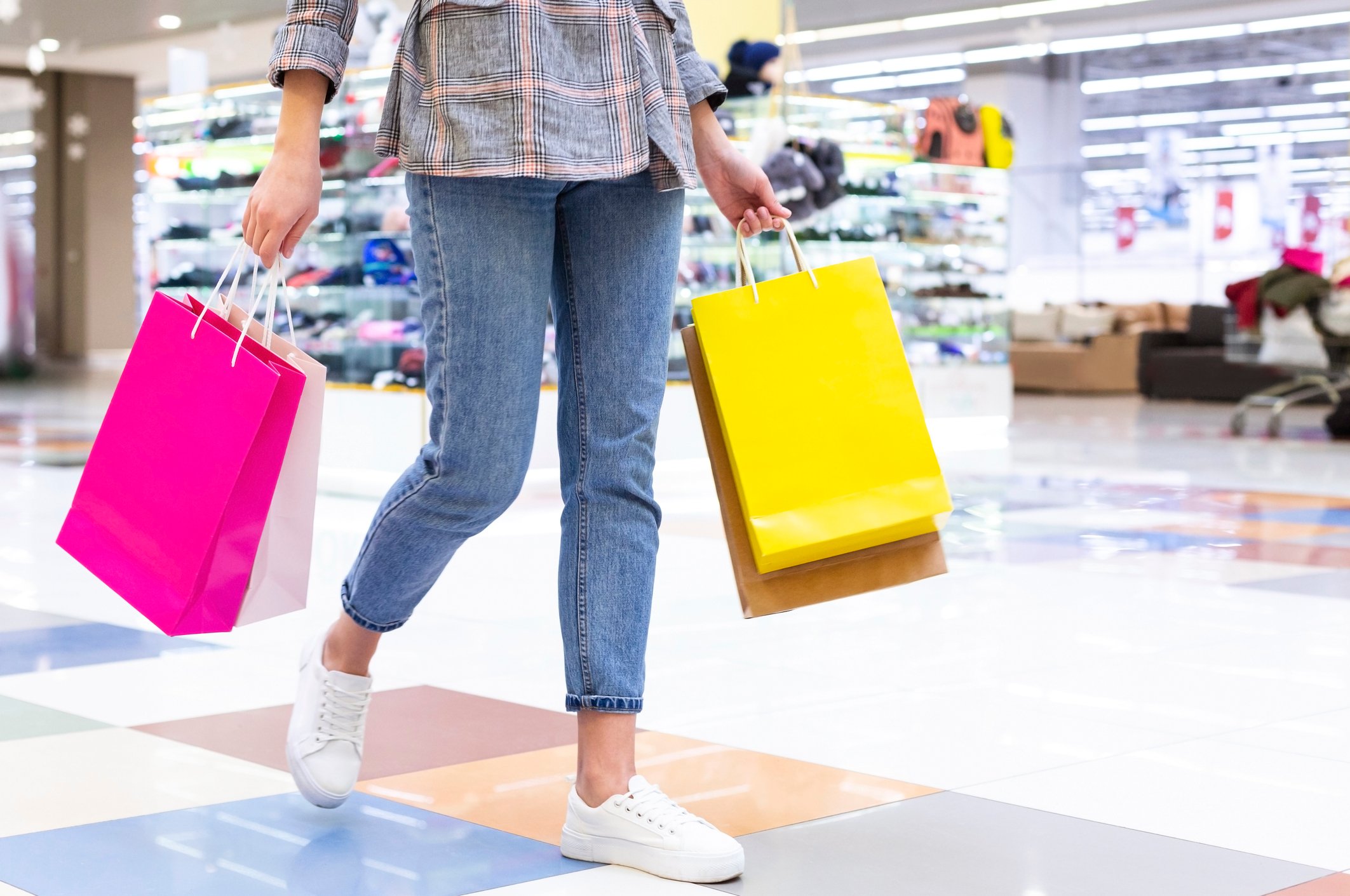 Woman holding shopping bags in a mall.