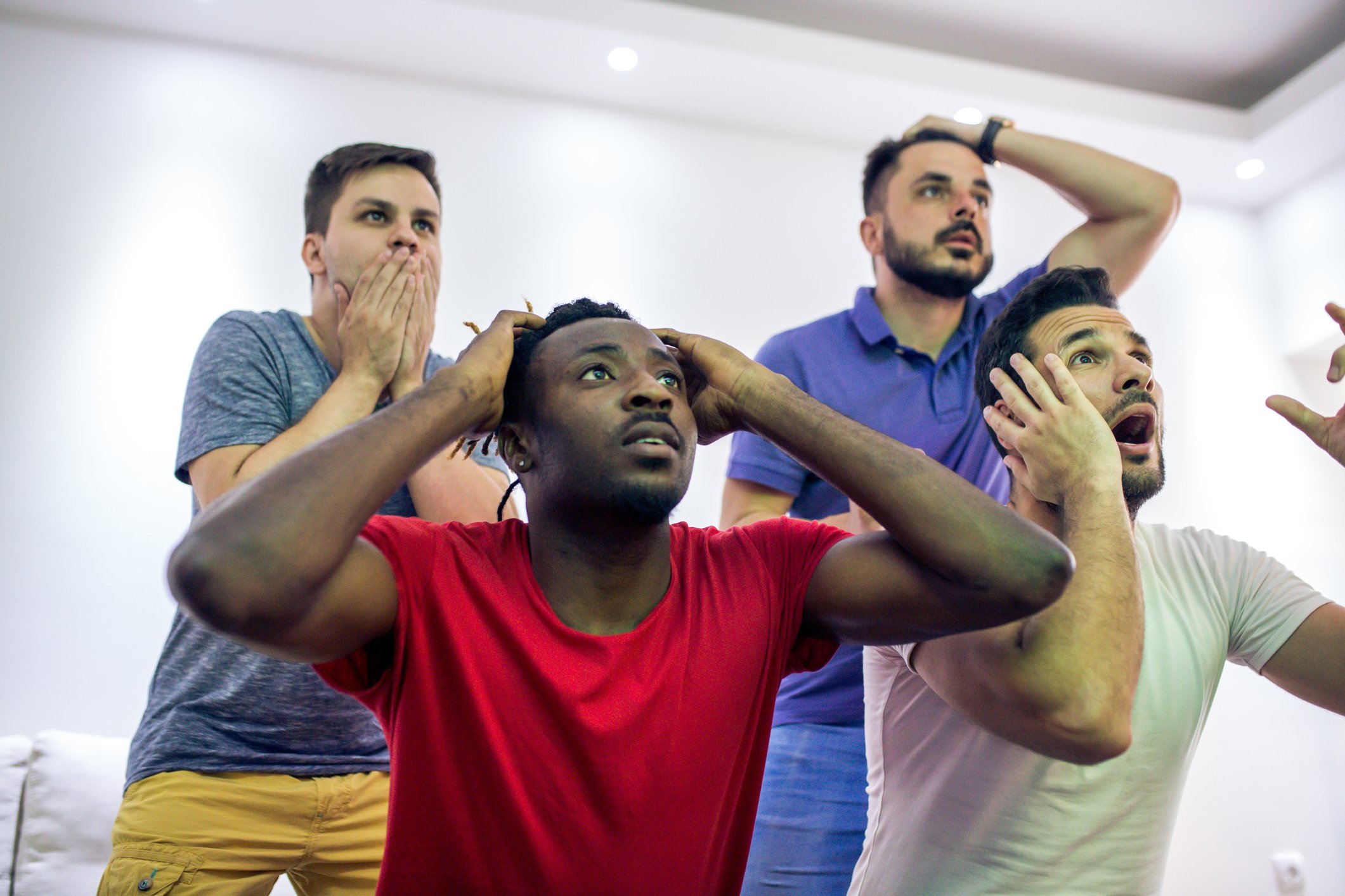 A group of male sports enthusiasts watching a game. 