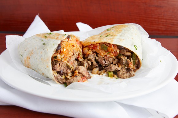 A steak burrito on a plate.