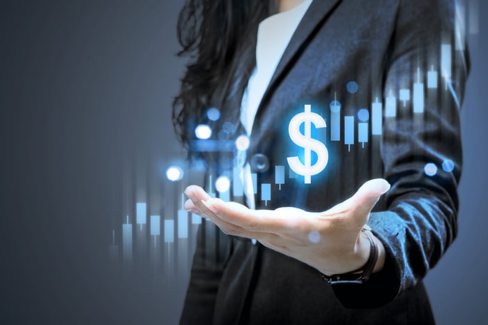 Woman holding hand out with images of an ascending stock chart and a dollar sign above her hand