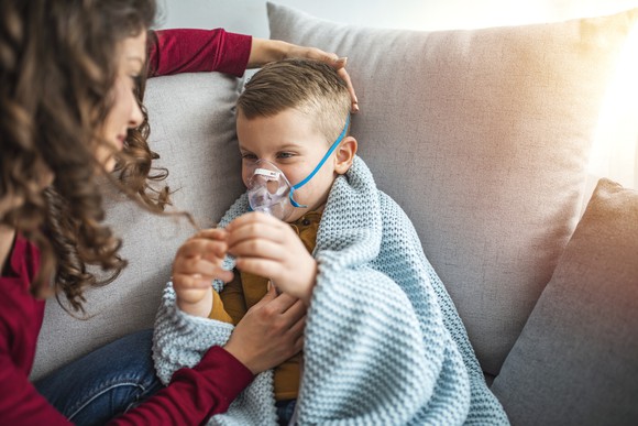 A child with cystic fibrosis gets an inhaler treatment.
