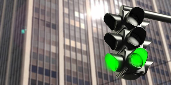 A green light in front of a modern office building, symbolizing regulatory approval.