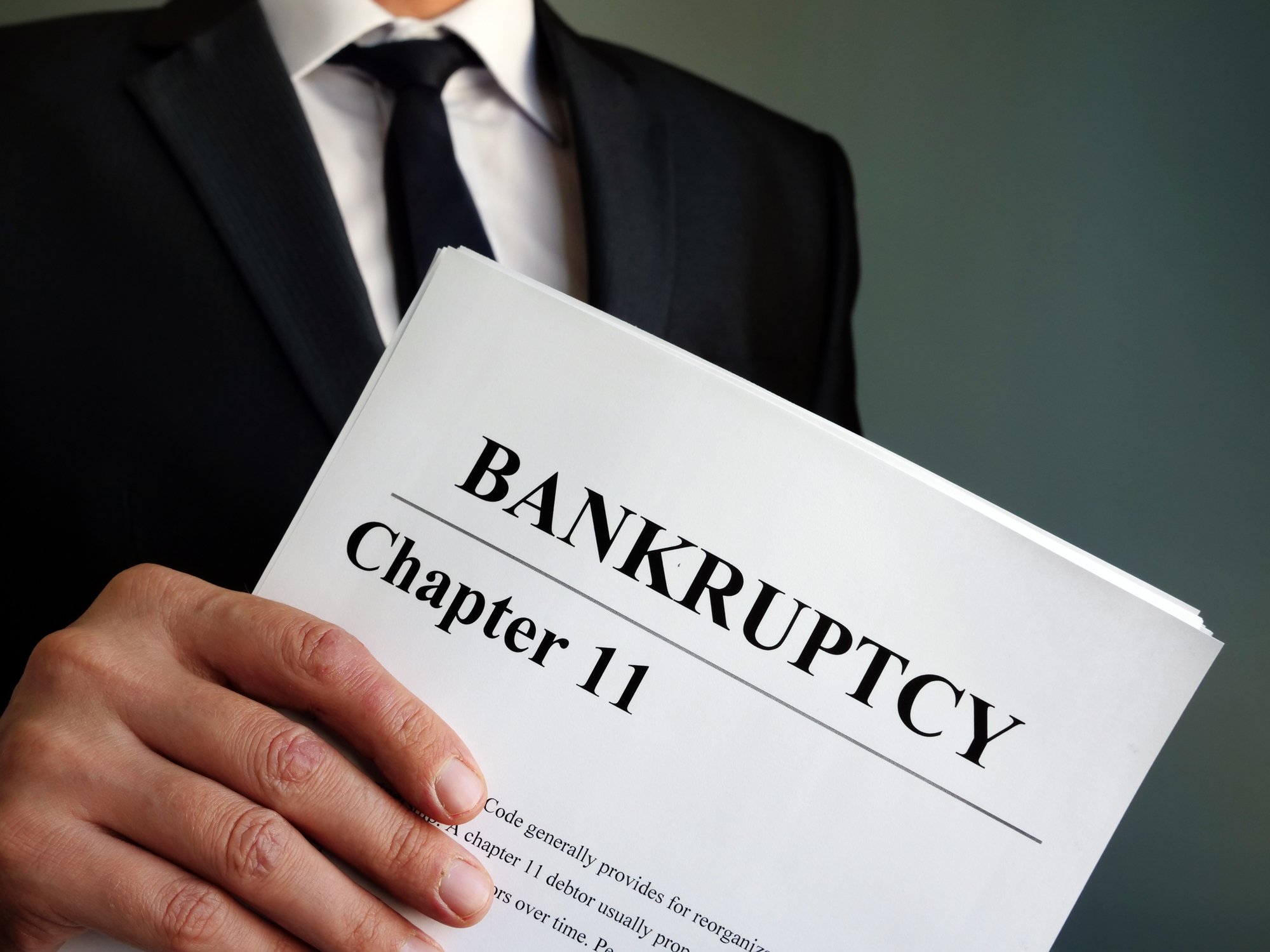 A lawyer holds a packet of bankruptcy papers.