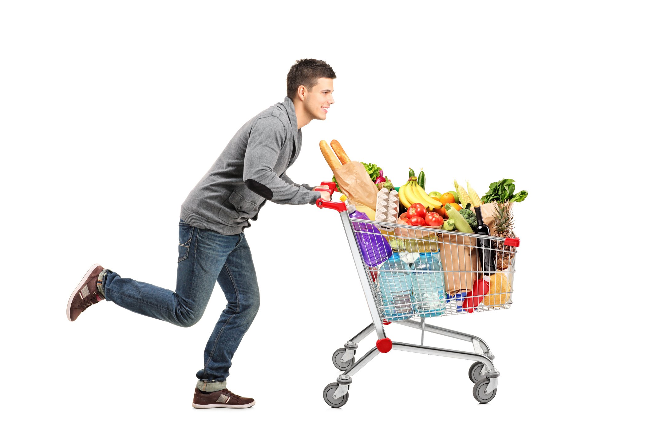 Young man running with a full grocery cart.
