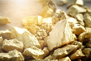 Gold nuggets on a flat surface.