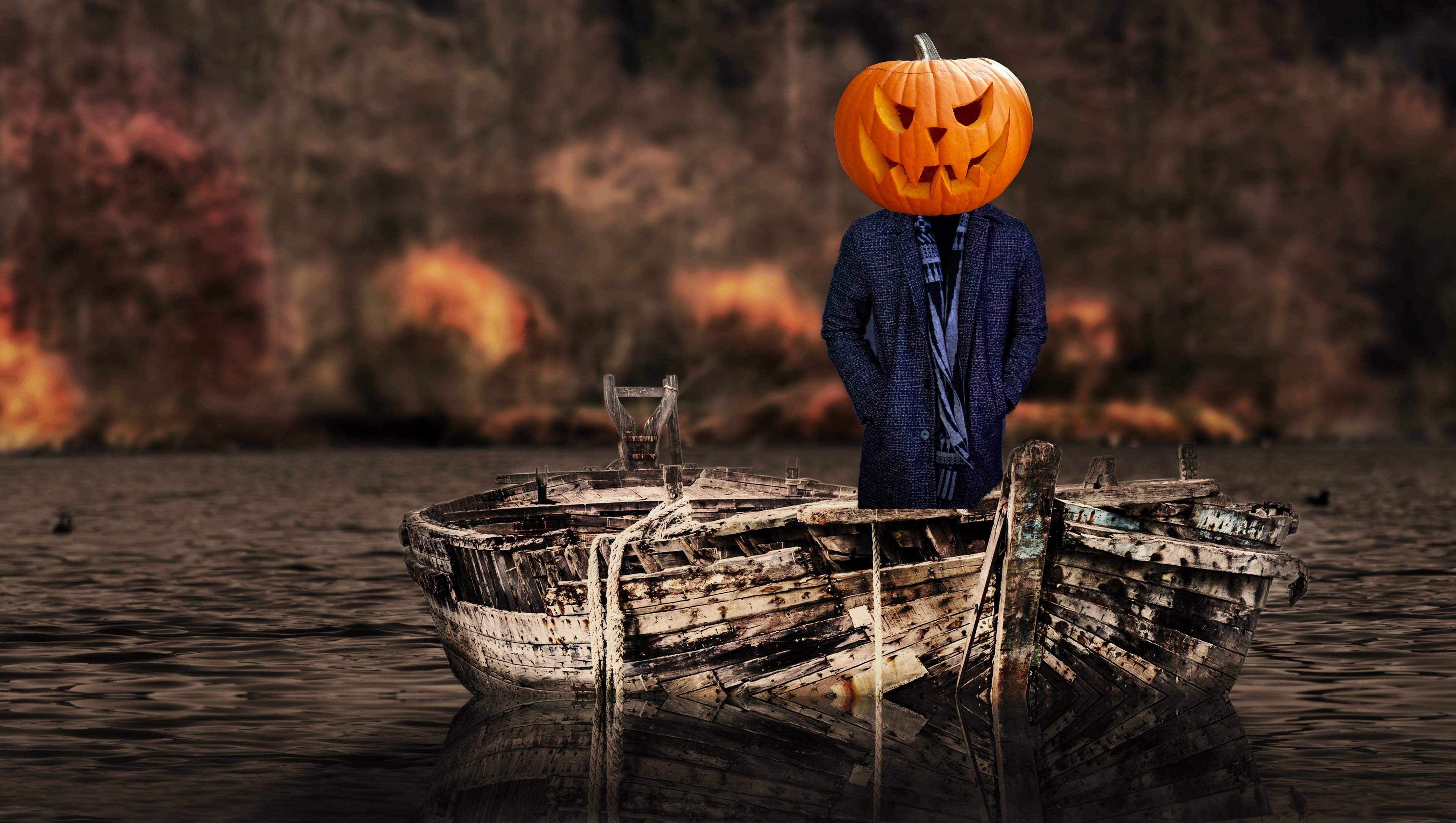 A person with a jack-o-lantern face standing on a rickety old boat.