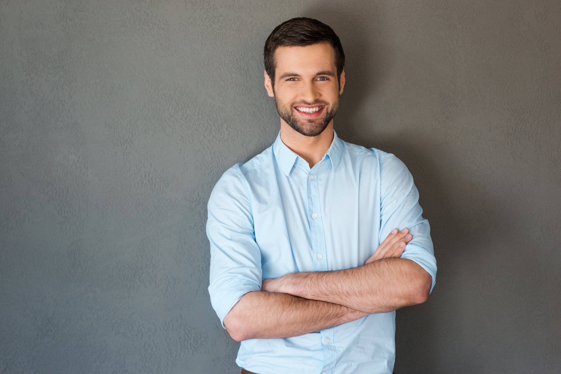 Smiling man in dress shirt against gray background