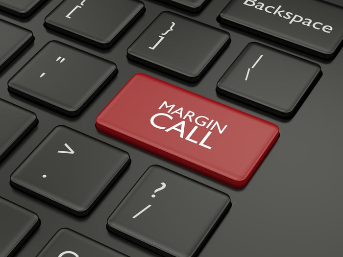 A picture of a black keyboard with a red margin call button