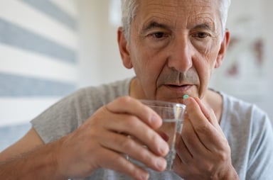 Older man taking a pill_GettyImages-1029339812