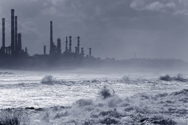 A strom hitting an oil refinery by the sea.