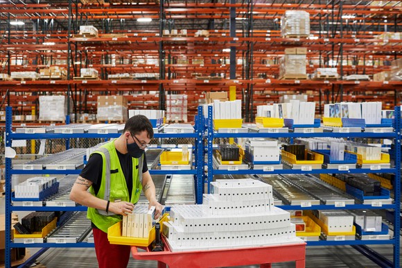 Workers prepare iPhone 12, iPhone 12 Pro, and iPad Air for shipment at Apple’s distribution center in Carlisle, Pennsylvania.