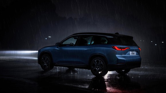A NIO ES8 driving in the rain at night.