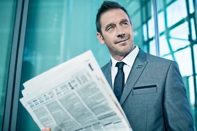 Businessman in Suit Reading Newspaper Getty