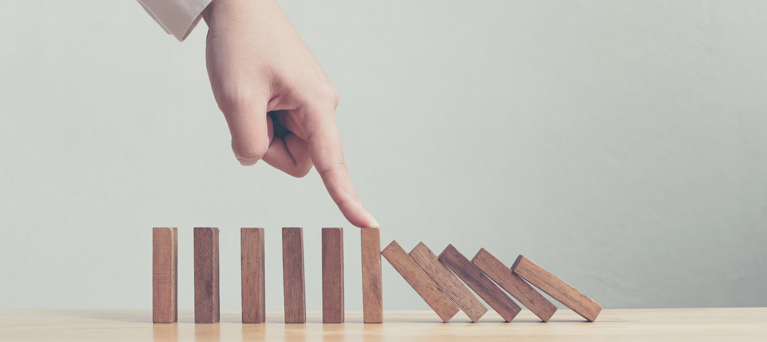 Hand stopping wooden domino.