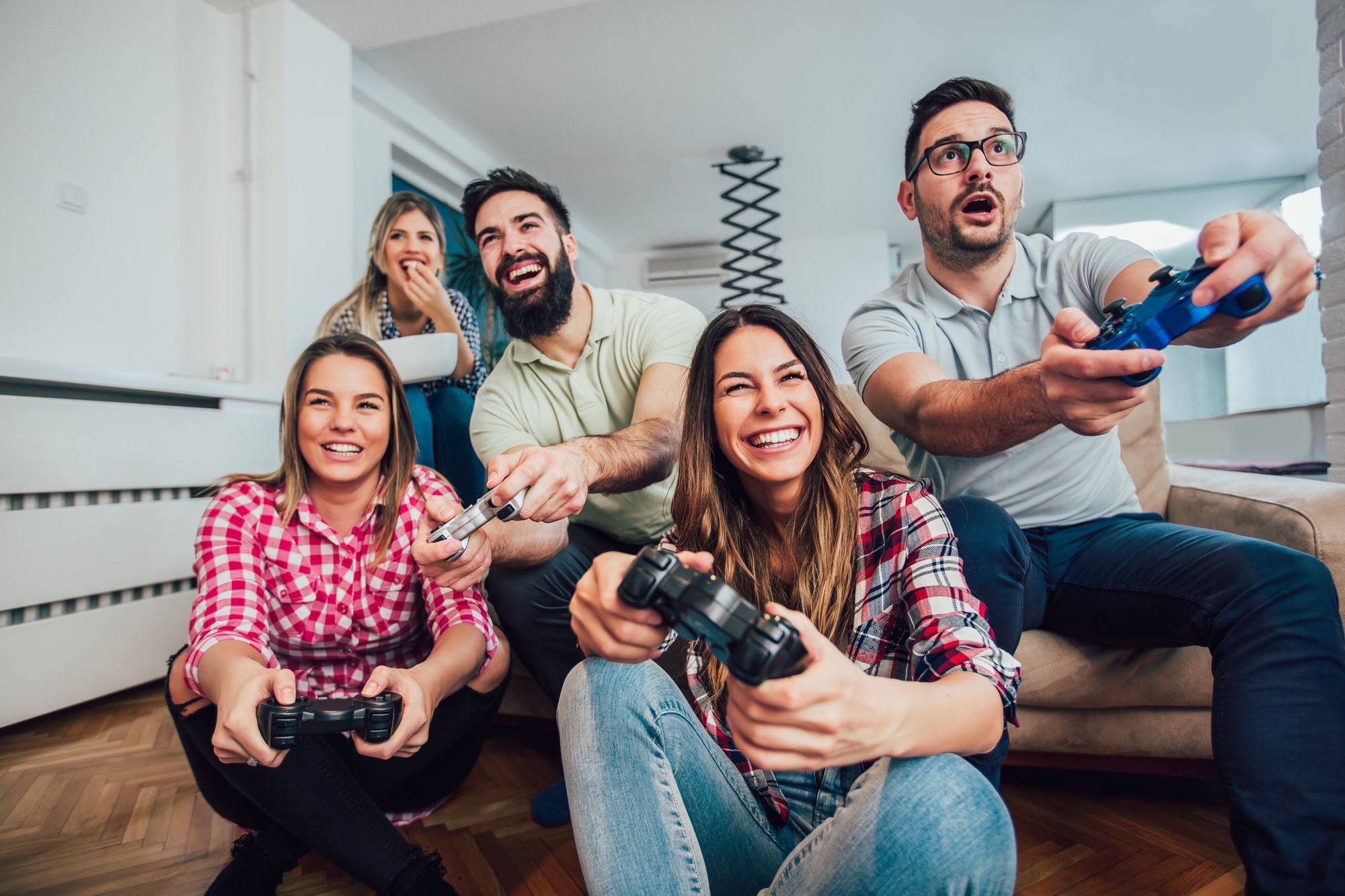 A group of young adults plays a video game.