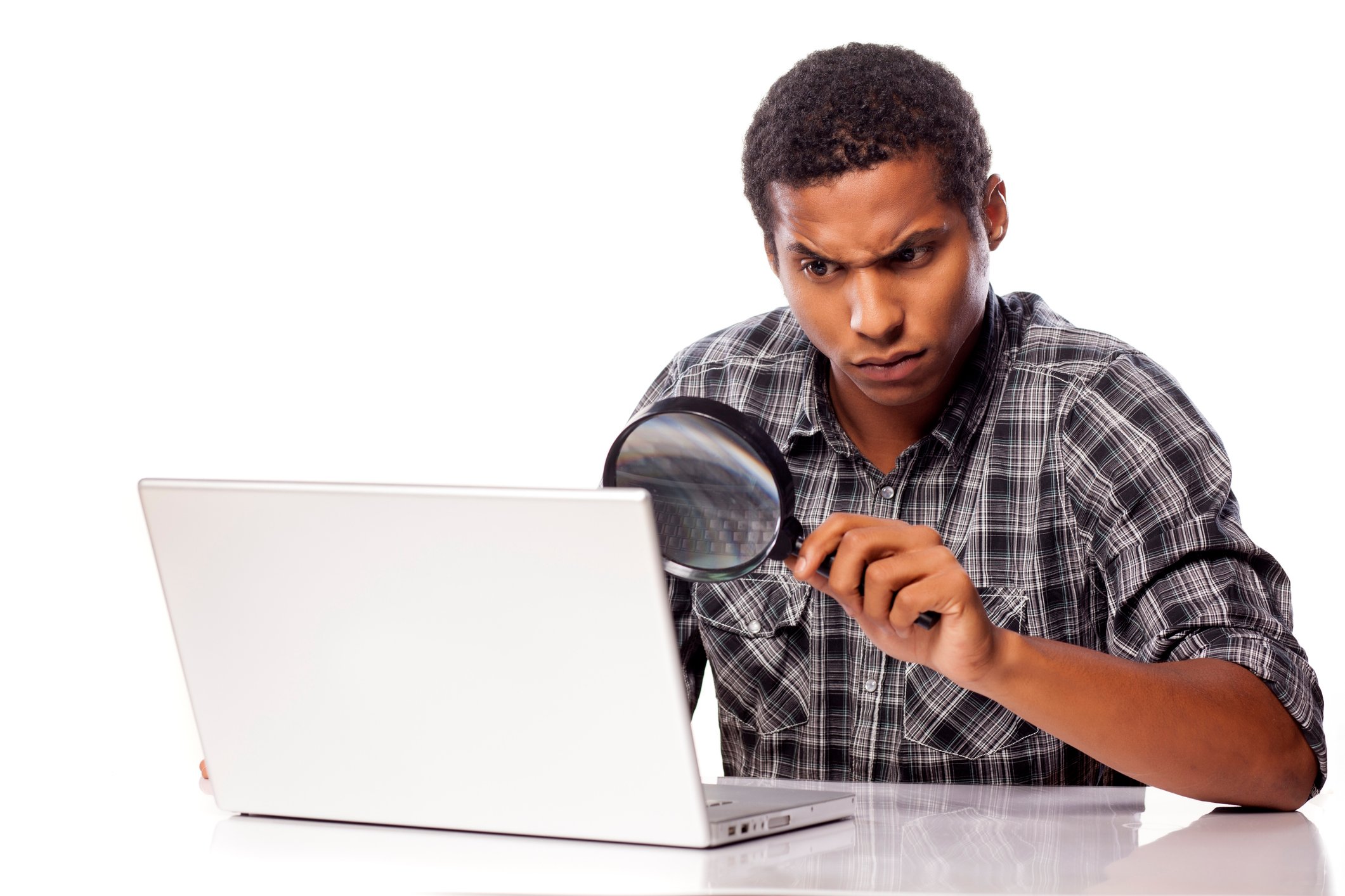 Man looking through magnifying glass at his computer screen