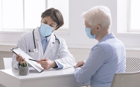 Doctor showing an older patient a report.