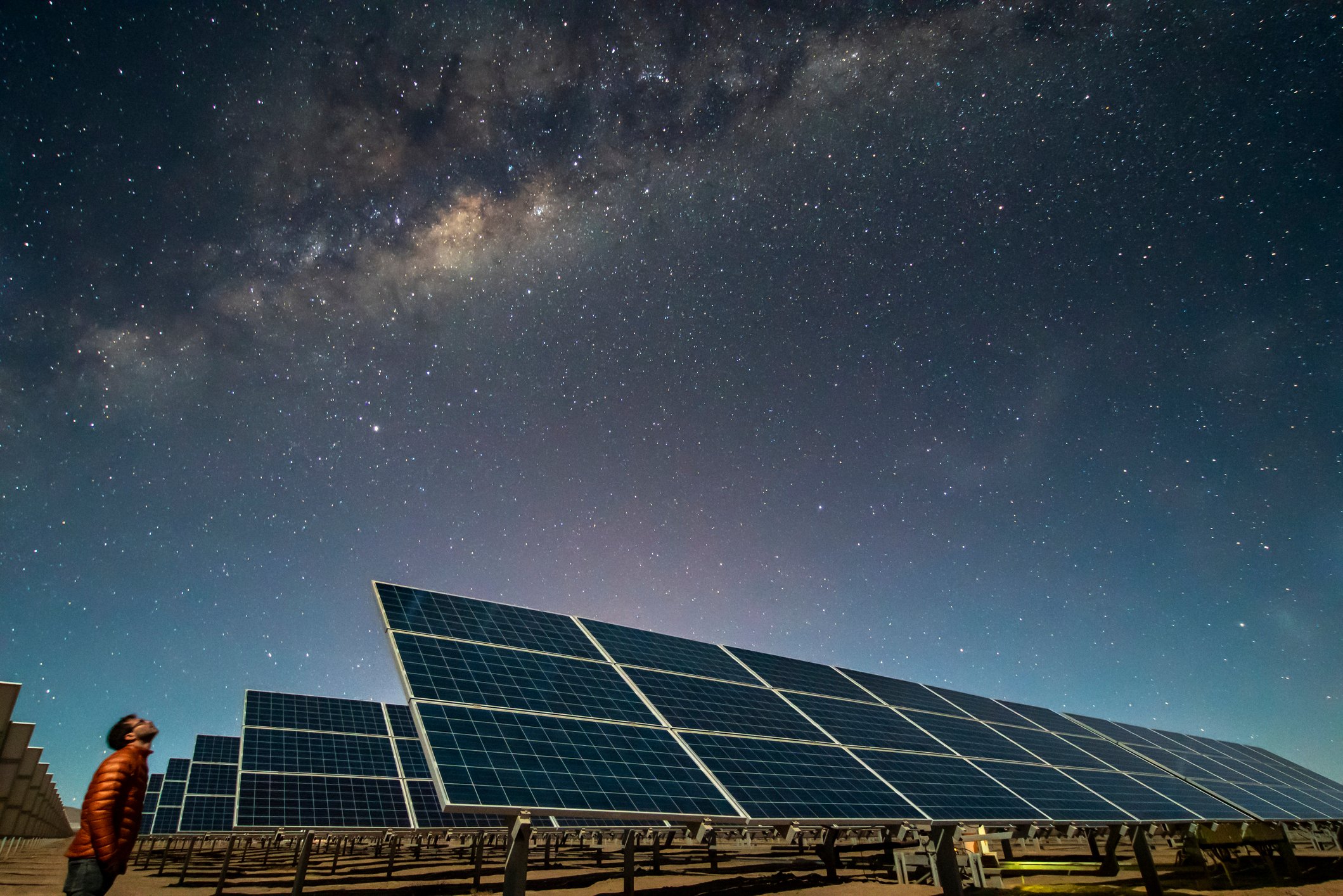 Solar panels under a starry night sky. 