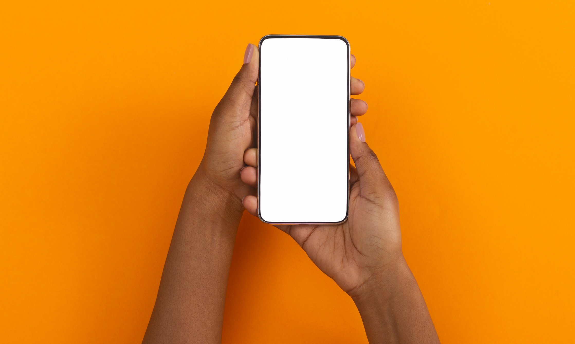Two hands hold a smartphone with a blank screen. 