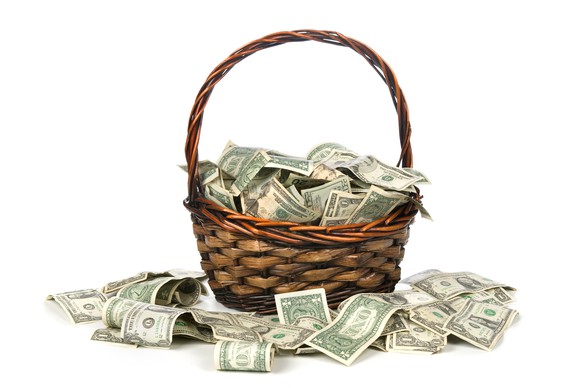Basket full of cash with cash surrounding it.  