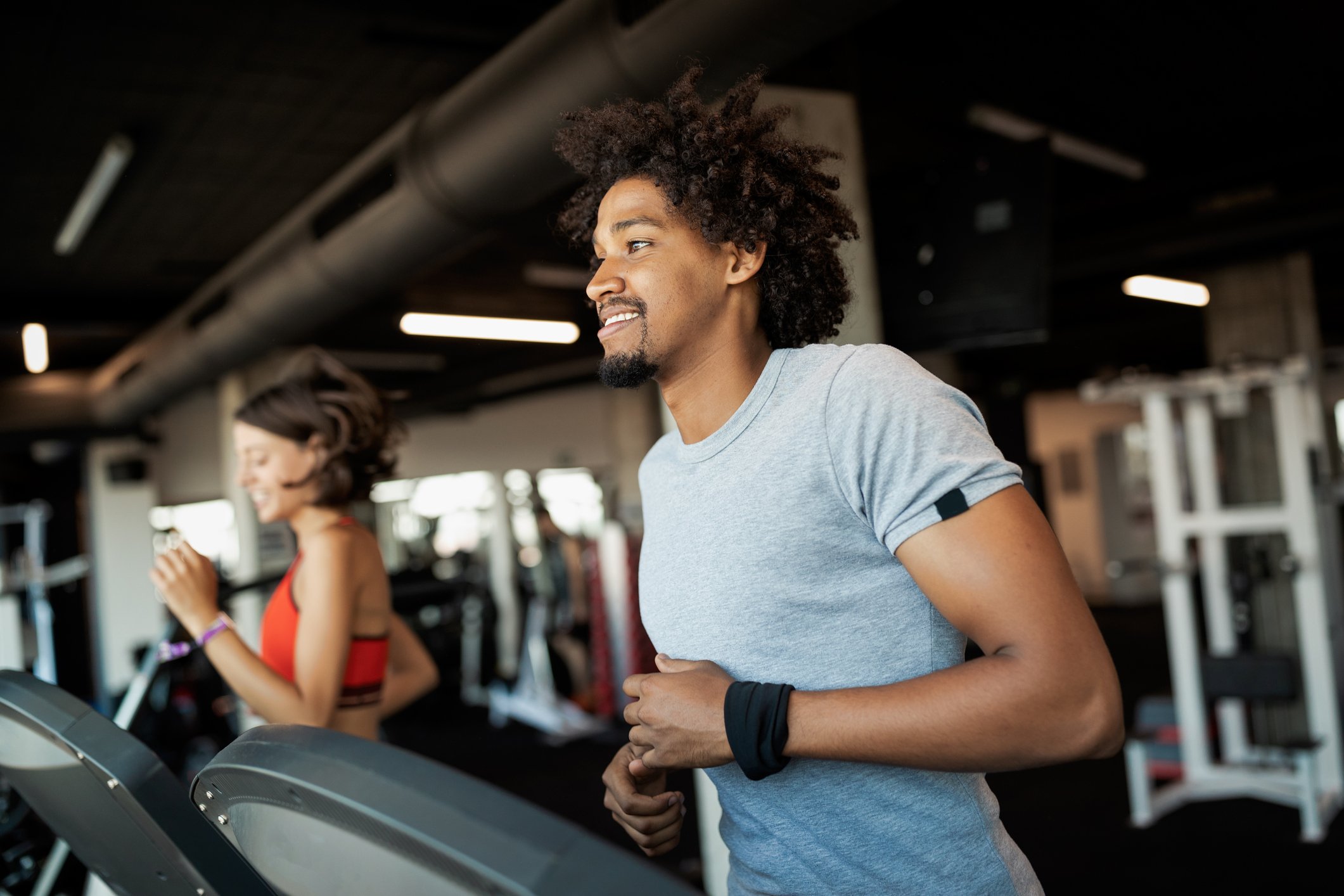 A man and a women running on treadmills in a gym