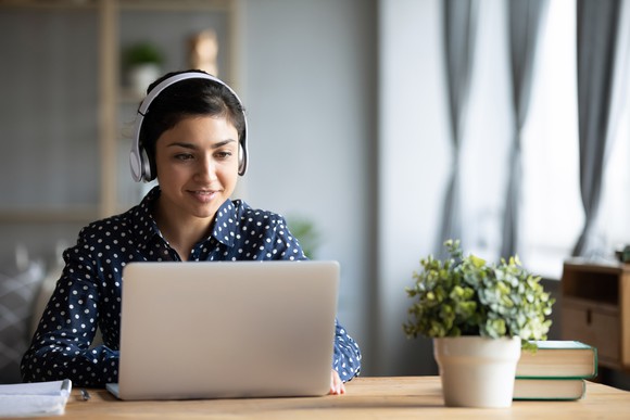 A young woman works at her laptop.