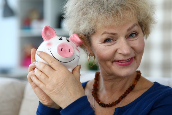 A woman holding up a piggy bank.