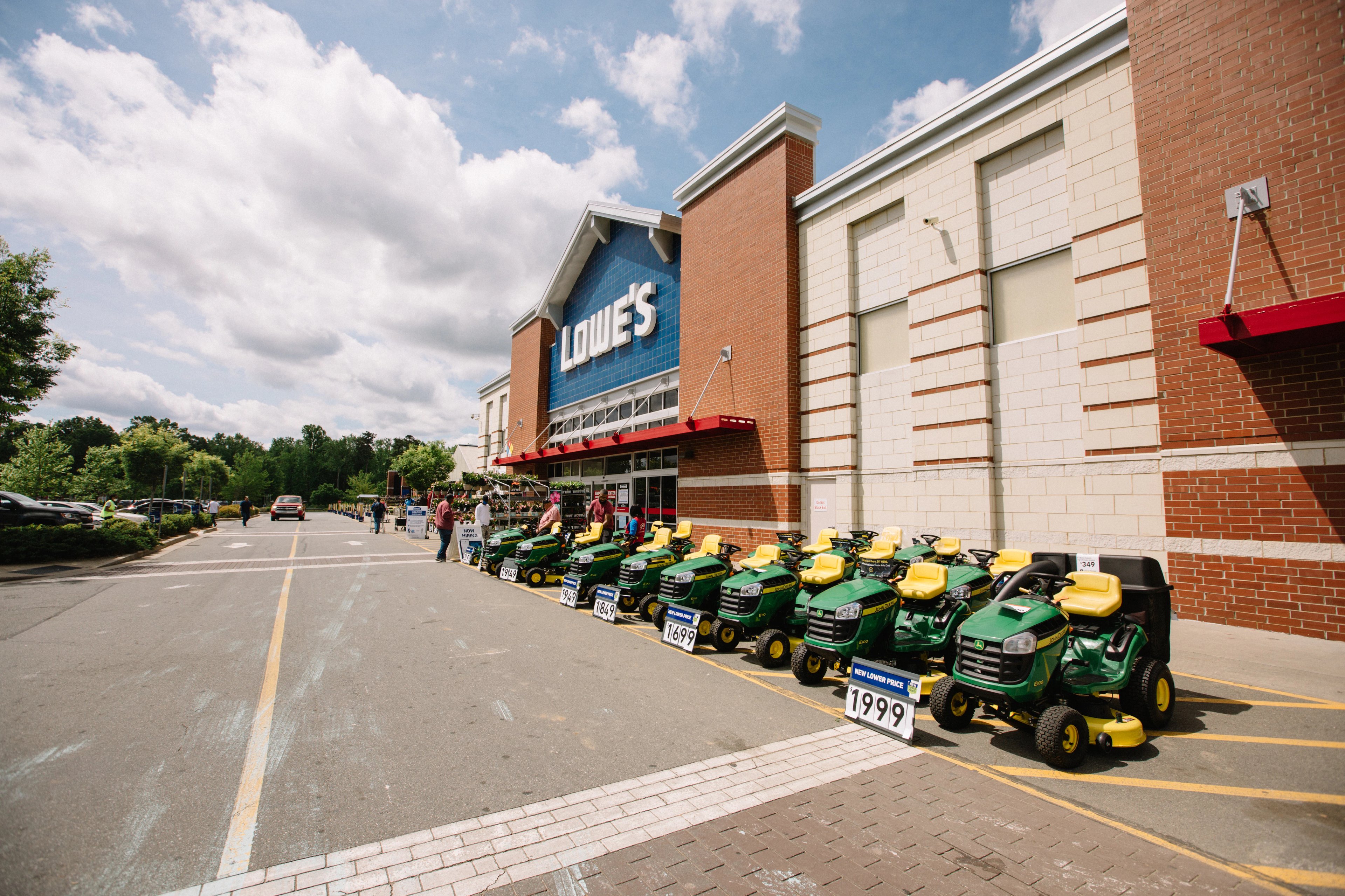 A Lowe's store with a display of tractors in front.
