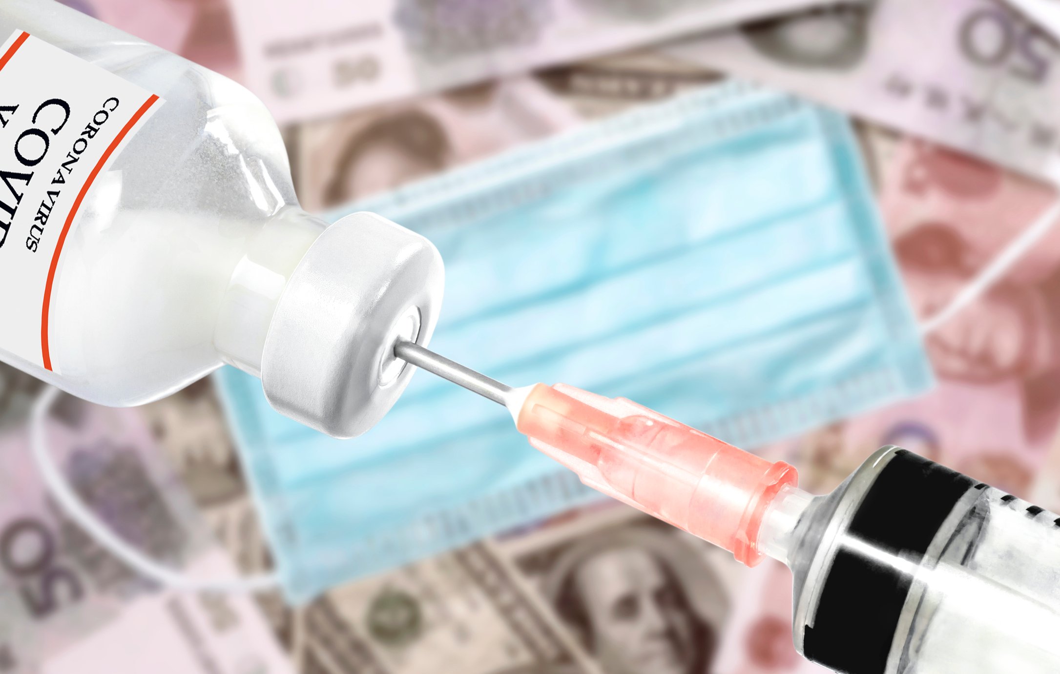 Cash, a surgical mask, and a needle going into a syringe.