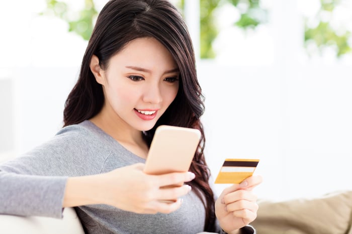 Chinese woman shopping on her phone with a credit card