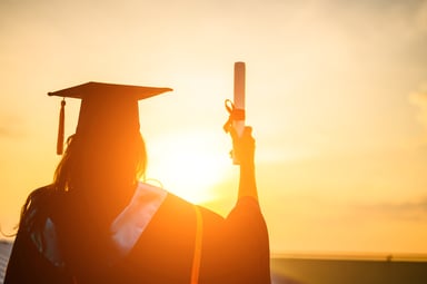 Silhouette of a college grauate holding a diploma