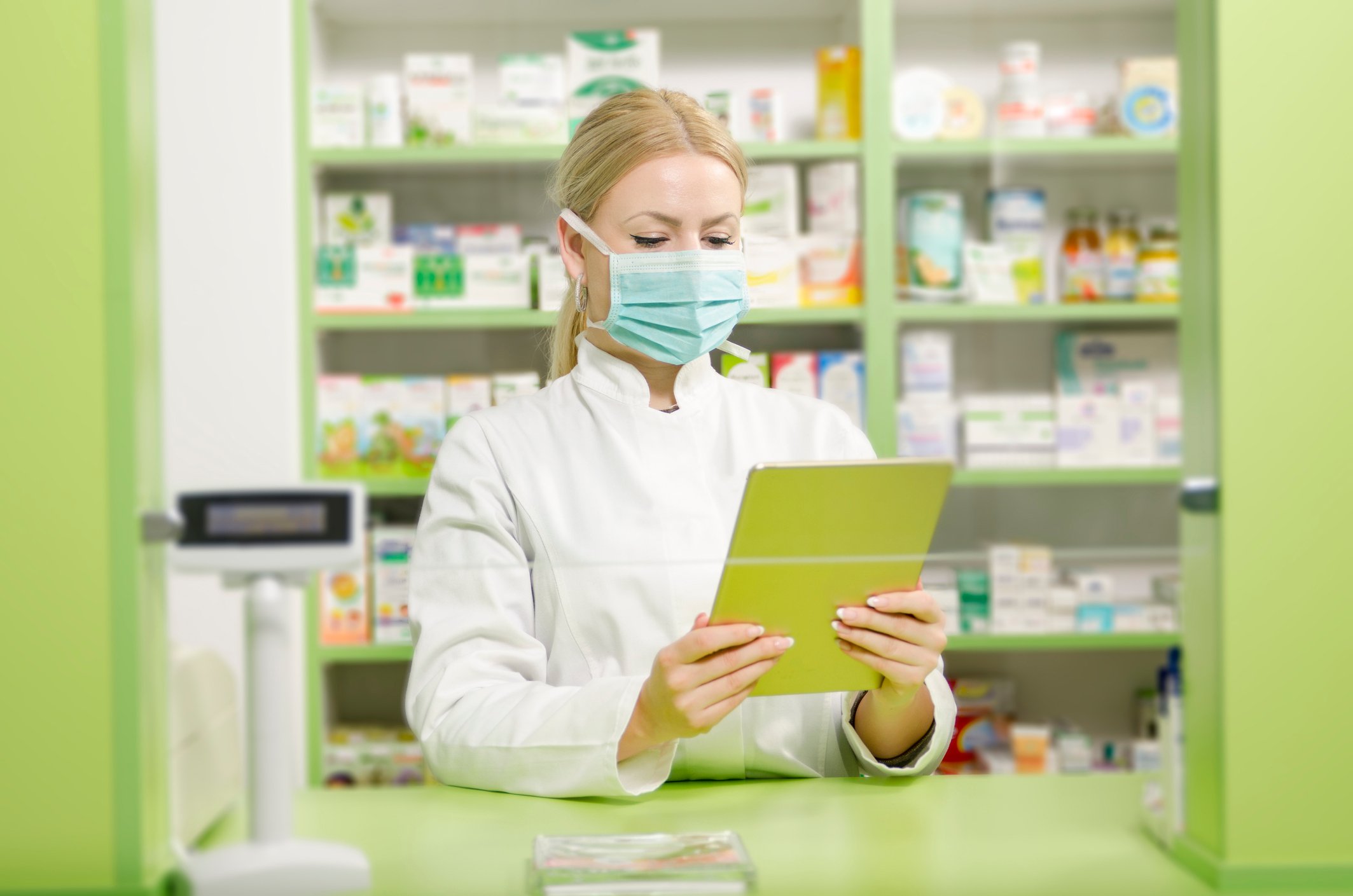 A pharmacist looks at a tablet.
