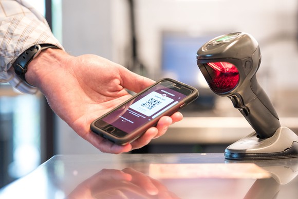 A scanner scan a bar code displayed on a smart phone in a Chipotle restaurant.