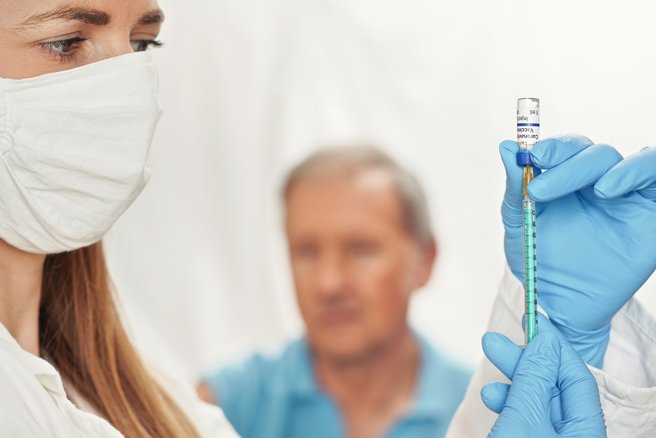 A nurse draws up vaccine to administer to a trial participant.