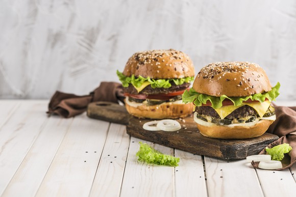 A pair of premium burgers on a cutting board.