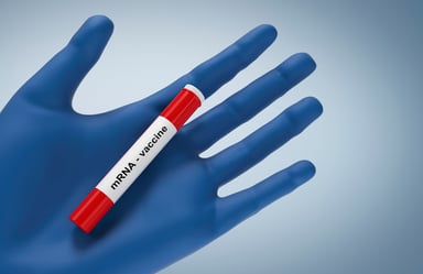 mRNA vaccine vial on palm