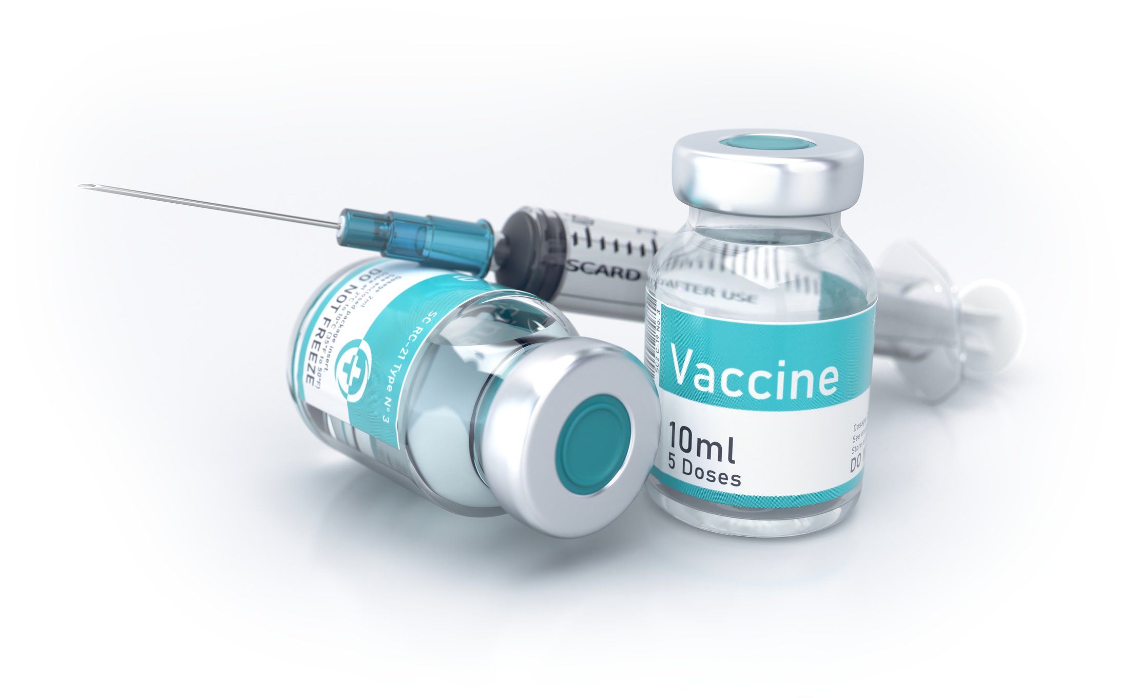 A syringe rests on two vials of vaccine.