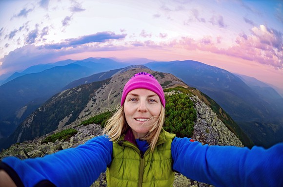 Woman capturing footage of herself on a climb.