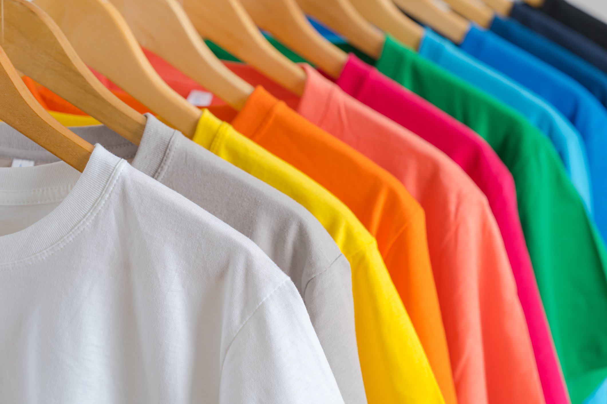 A hung-up row of shirts in all different colors.