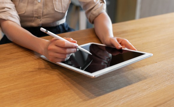 A person signs a document on an electronic tablet.