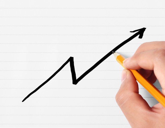 A person draws a line that rises, then falls, then rises again.