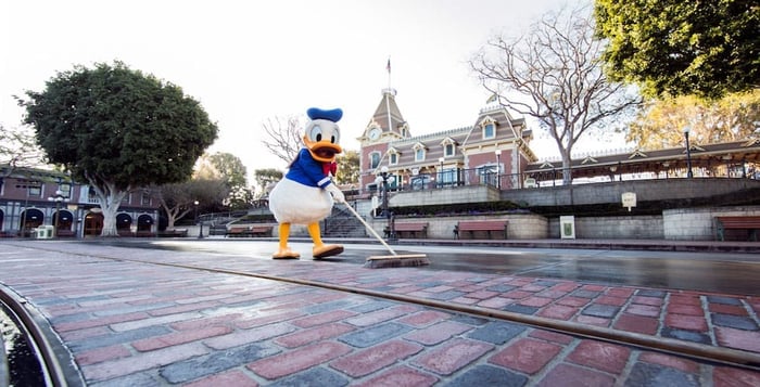 Donald Duck sweeping Main Street U.S.A. with a broom.