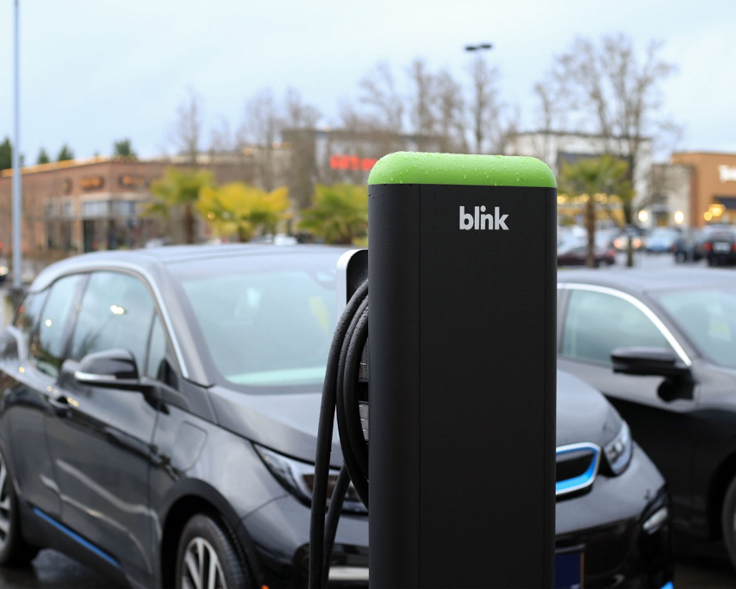 A Blink EV charging station next to cars