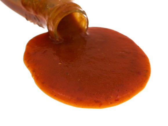 red hot sauce being poured out of a bottle