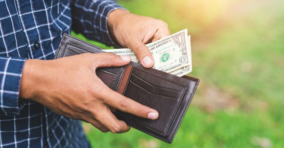 Hands holding a wallet and pulling $1 bills out.
