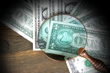 Dollar bills under a looking glass